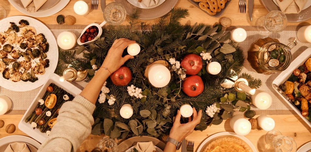 A top-down view of a festive holiday table setting with candles and decorations, perfect for Christmas or New Year's dinner.